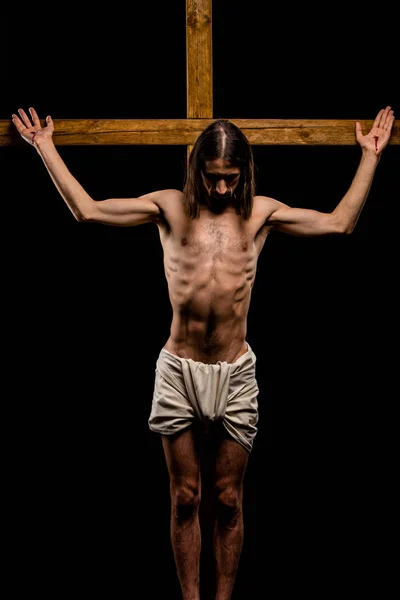 Shirtless jesus crucified on wooden cross isolated on black — Stock Photo