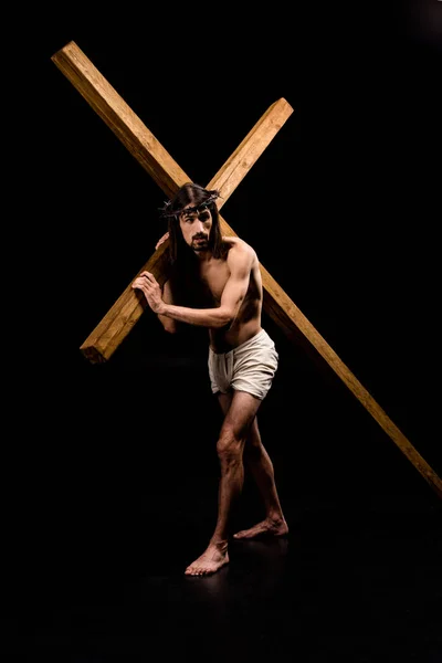 Jesus im Kranz mit Holzkreuz und auf schwarz stehend — Stockfoto