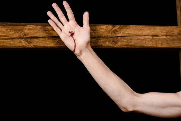 Cropped view of jesus crucified on wooden cross isolated on black — Stock Photo