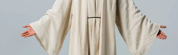 Panoramaaufnahme eines Mannes im Jesusgewand mit ausgestreckten Händen isoliert auf grau — Stockfoto
