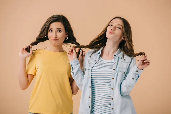 Attraktiv und junge Freunde spielen mit Haaren isoliert auf beige — Stockfoto