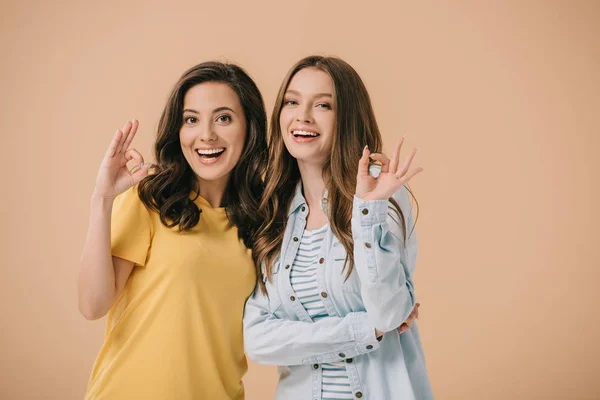 Attractive and smiling friends showing okay isolated on beige — Stock Photo