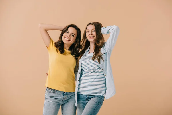 Amici attraenti e sorridenti guardando la fotocamera isolata sul beige — Foto stock