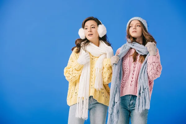 Attractive women in sweaters and scarves feeling hot isolated on blue — Stock Photo