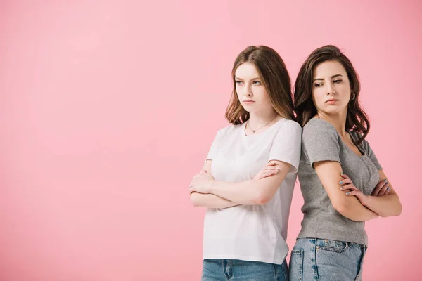 Donne attraenti e tristi in t-shirt con le braccia incrociate distogliendo lo sguardo isolato sul rosa — Foto stock