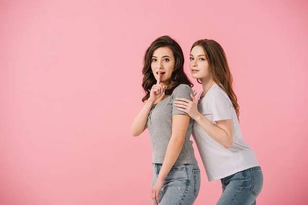 Donne attraenti in t-shirt che mostrano gesto shh isolato su rosa — Foto stock