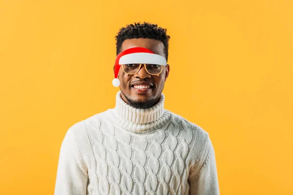 Hombre afroamericano en jersey de invierno y gafas de Navidad aisladas en amarillo - foto de stock