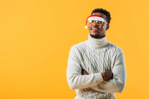 Afrikanisch-amerikanischer Mann mit verschränkten Armen im Winterpullover und Weihnachtsbrille isoliert auf gelb — Stockfoto