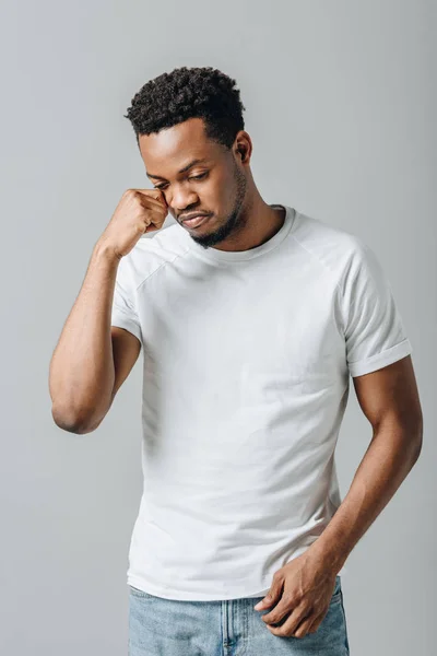 African American man in white T-short crying and looking down isolated on grey — Stock Photo