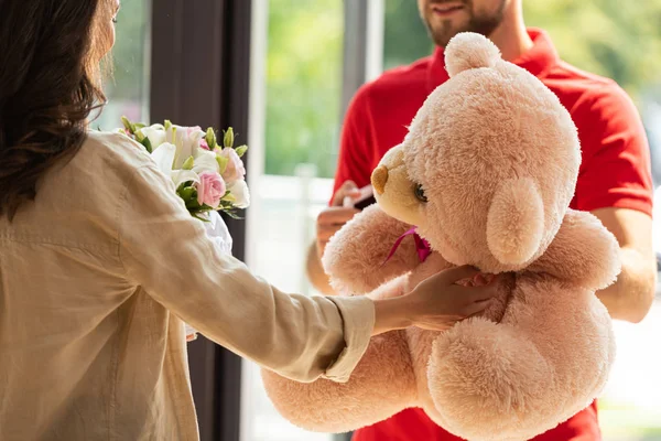 Cropped view of woman receiving gifts from delivery man — Stock Photo