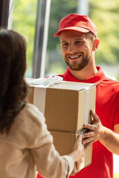 Cropped view of woman receiving carton box from delivery man — Stock Photo