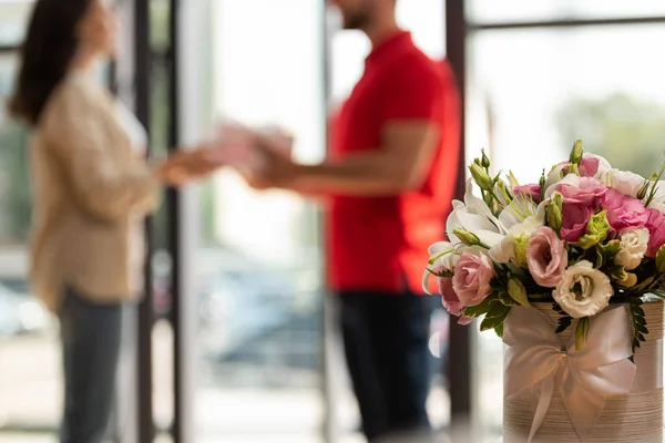 Selective focus of eustoma flowers near man and woman — Stock Photo