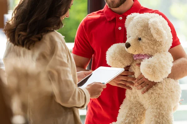 Vue recadrée de la femme tenant tablette numérique près de l'homme avec ours en peluche — Photo de stock