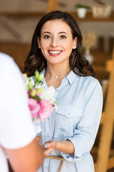 Ausgeschnittener Blick auf Liefermann, der fröhliche Frau Blumen schenkt — Stockfoto