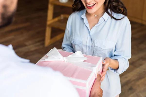 Vue recadrée de femme heureuse recevant cadeau de l'homme de livraison — Photo de stock