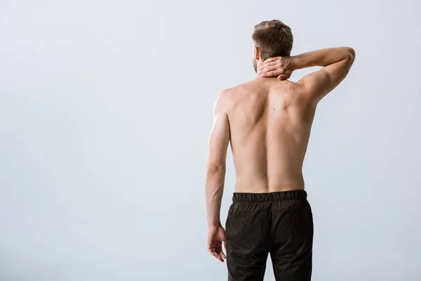 Back view of shirtless man with neck pain isolated on grey — Stock Photo