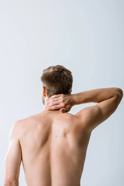 Вид сзади безрубашечного мужчины с болью в шее, изолированного на сером — стоковое фото