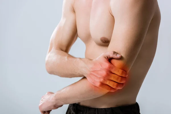 Vue partielle de l'homme torse nu avec douleur au coude isolé sur gris — Photo de stock