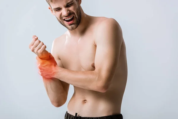 Hemdloser bärtiger Mann mit Schmerzen am Handgelenk isoliert auf grau — Stockfoto