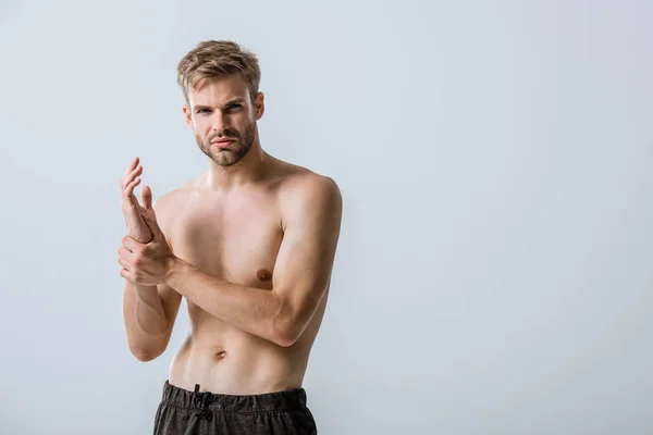 Hemdloser bärtiger Mann mit Schmerzen am Handgelenk isoliert auf grau — Stockfoto
