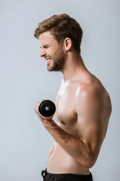 Вид збоку спортсмена без сорочки з використанням барбелла ізольовано на сірому — стокове фото