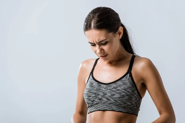 Displeased attractive sportswoman looking down isolated on grey — Stock Photo