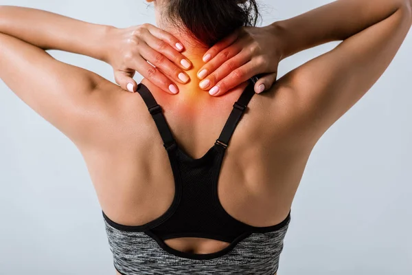 Cropped view of sportswoman with neck pain isolated on grey — Stock Photo