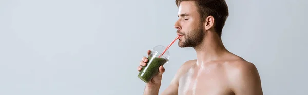 Plan panoramique d'un sportif barbu torse nu buvant un smoothie isolé sur fond gris — Photo de stock