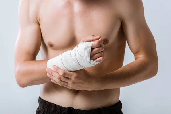 Cropped view of shirtless sportsman with elastic bandage on wrist isolated on grey — Stock Photo