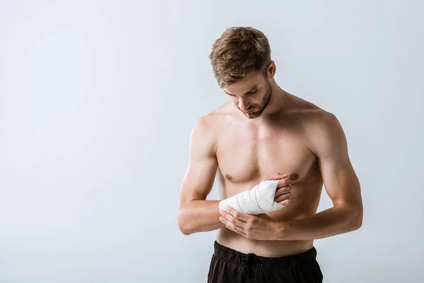 Hemdloser Sportler mit elastischem Verband am Handgelenk isoliert auf grau — Stockfoto