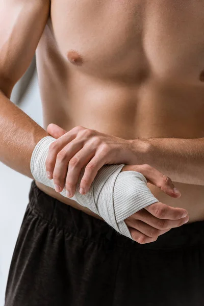 Cropped view of shirtless sportsman with elastic bandage on wrist isolated on grey — Stock Photo