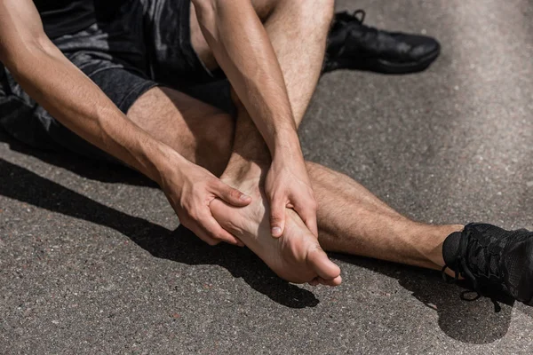 Teilbild eines barfüßigen Sportlers mit Fußschmerzen auf der Straße — Stockfoto