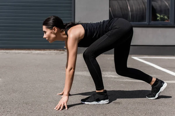 Vue latérale de la sportive se préparant à courir dans la rue — Photo de stock