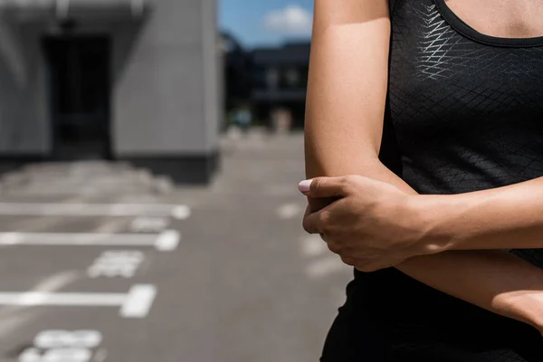 Teilansicht einer Sportlerin, die an einem sonnigen Tag auf der Straße steht — Stockfoto