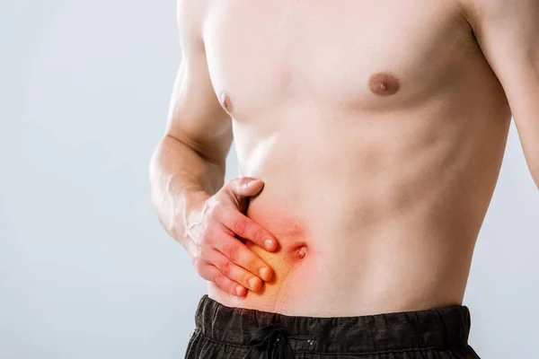 Cropped view of shirtless sportman with abdominal pain isolated on grey — Stock Photo