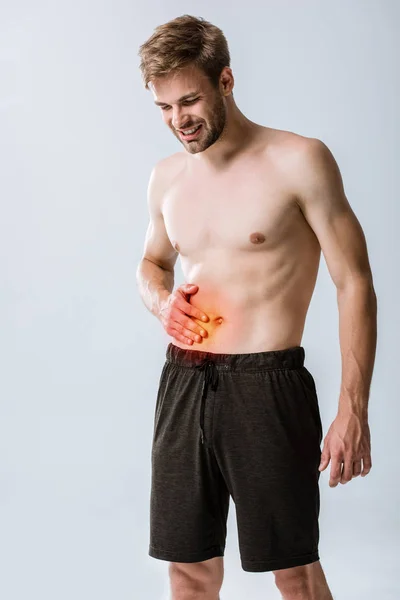 Deportista sin camisa con dolor abdominal aislado en gris - foto de stock