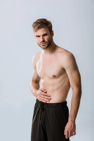 Hemdloser Sportler mit Bauchschmerzen isoliert auf grau — Stockfoto
