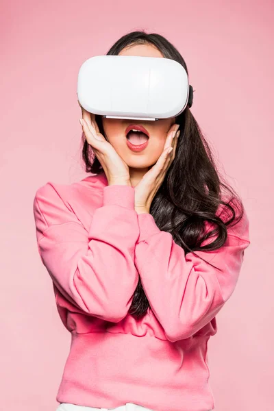 Donna scioccata in pullover rosa con auricolare realtà virtuale isolato su rosa — Foto stock