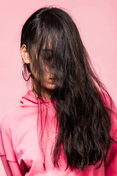Atractiva mujer asiática en suéter rosa con los ojos cerrados aislados en rosa - foto de stock