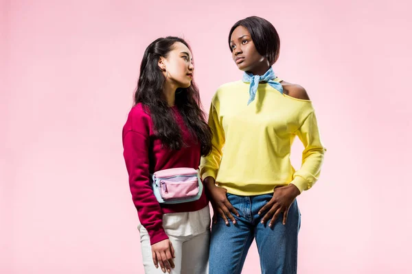 Attractive asian and african american friends looking away isolated on pink — Stock Photo