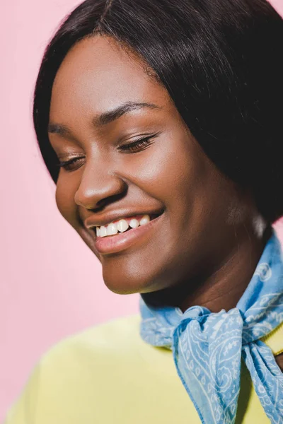Улыбающаяся африканская американка в голубом шарфе, изолированном на розовом — стоковое фото