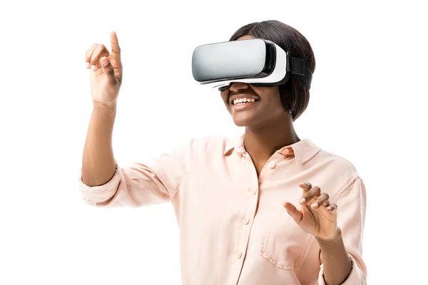 Femme afro-américaine en chemise avec casque de réalité virtuelle pointant du doigt isolé sur blanc — Photo de stock