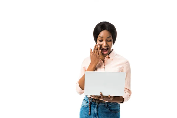 Chocado afro-americano mulher na camisa usando laptop isolado no branco — Fotografia de Stock