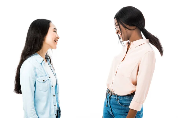 Sorridente asiatica e africana americana amici guardando l'un l'altro isolato su bianco — Foto stock