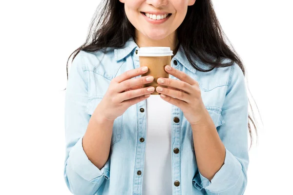 Vista ritagliata di donna sorridente in camicia di jeans tenendo tazza di carta isolata su bianco — Foto stock