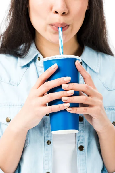 Обрезанный вид женщины в джинсовой рубашке пить из пластиковой чашки изолированы на белом — стоковое фото