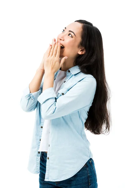 Attractive and shocked asian woman in denim shirt looking away isolated on white — Stock Photo