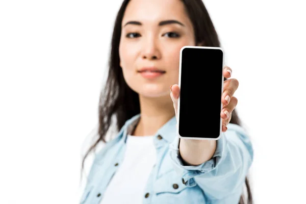 Selektiver Fokus attraktiver asiatischer Frau in Jeanshemd mit Smartphone und Kopierraum isoliert auf Weiß — Stockfoto
