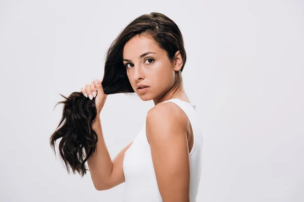 Brunette beautiful woman holding long healthy and shiny hair isolated on grey — Stock Photo