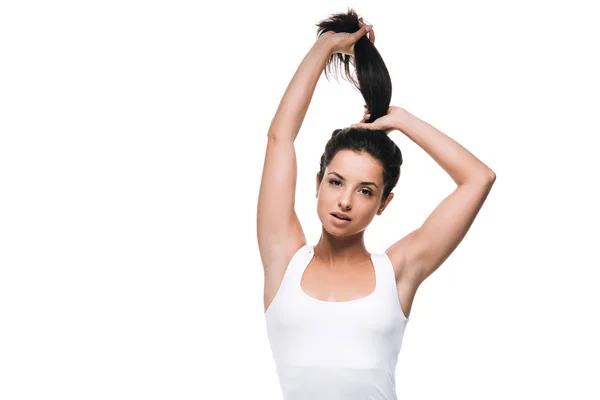 Брюнетка красивая женщина держит длинные прямые здоровые и блестящие волосы в хвосте изолированы на белом — стоковое фото